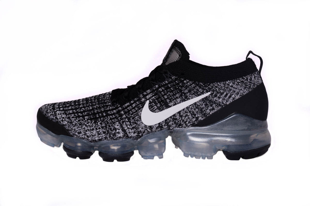 Nike Air Vapormax Flyknit 3 from a side angle in a black and grey colourway. The trainer also features a signature Nike swoosh along the side.
